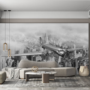 Black & White Wallpaper | Airplane Flying Above The Buildings Mural